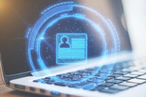 Glowing blue digital profile card floating above a laptop keyboard, symbolizing online identity verification.